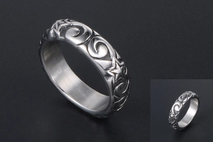 Detail of vintage silver star ring showing matte texture and swirl pattern engraving
