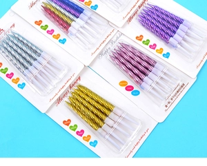 Close-up of metallic spiral birthday candles in gold, silver, and purple with white bases