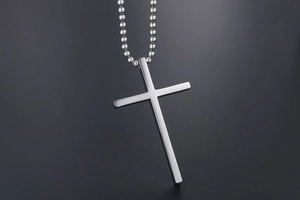 Detailed view of a silver titanium steel cross pendant necklace with a polished bead chain