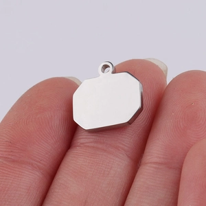 Polished silver octagon titanium steel pendant with hanging loop on a minimalist background