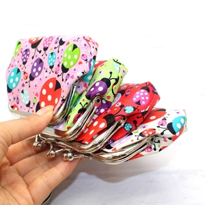 Handheld stack of ladybug print canvas coin purses with metal clasps in various colors