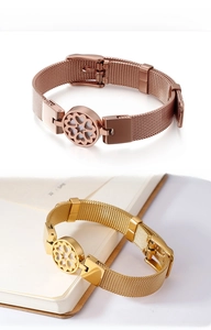 Detail of stainless steel mesh bracelet featuring a hollow clover heart centerpiece