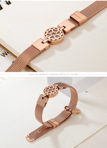 Macro detail of rose gold mesh bracelet featuring a heart flower cutout decorative charm