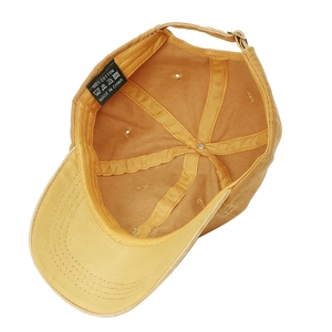 Detailed interior of yellow cotton baseball cap with adjustable metal buckle and inner lining