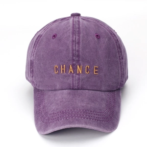 Detail view of purple washed cotton baseball cap with gold CHANCE embroidery