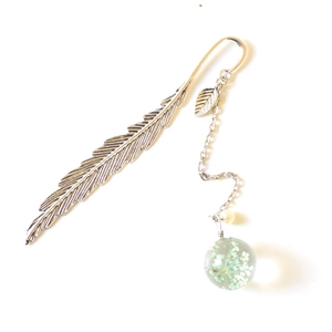 Silver metal feather bookmark with a glass orb pendant containing real dried flowers