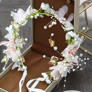 Detail of floral bridal headband with pink flowers and gold butterfly in a gift box
