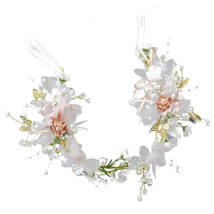 Detail of floral bridal headband with white flowers, pearls and golden butterflies
