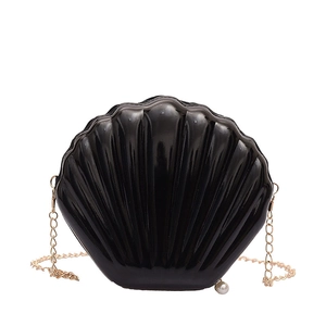 Chic black shell-shaped crossbody bag with pearl detail and golden chain strap