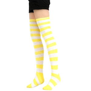 Détail de chaussettes hautes rayées jaunes et blanches montrant la texture du tricot