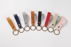 Close-up of colorful leather keychains with lychee texture and golden rivets for gift