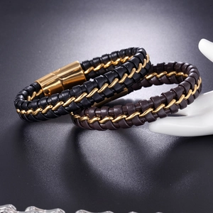 Close-up of woven leather men's bracelets in black and brown with golden chains