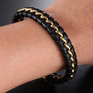 Macro shot of black leather and gold stainless steel chain braided bracelet on wrist