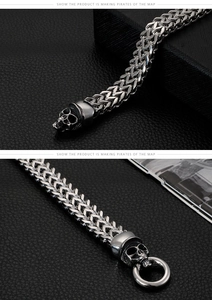 Detailed macro view of punk silver skull buckle on rugged woven titanium steel bracelet