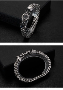 Detailed macro view of silver steel curb chain with intricate skull head charms
