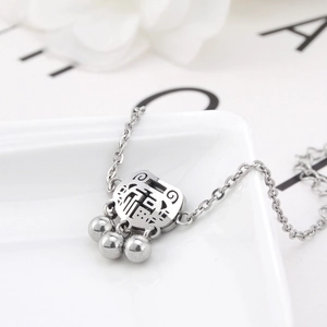 Detail of silver longevity lock pendant with Fù character and three small bells