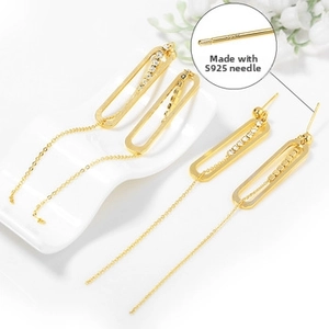 Detailed close-up of S925 silver ear hooks with gold tassels and cubic zirconia accents