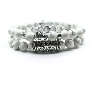 Detail of beaded bracelets with white howlite stone, silver Buddha head and floral spacers
