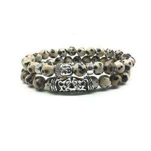 Detailed close-up of Buddhist head bead and patterned tube on Dalmatian Jasper bracelets