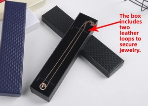Detail view of long black jewelry box with dual elastic bands to secure necklaces