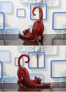 Detailed view of a stretching red cat sculpture with polished marble texture and glossy finish