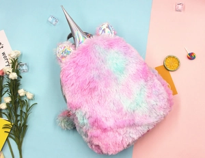 Detail of plush unicorn backpack featuring colorful tie-dye fur and holographic horn