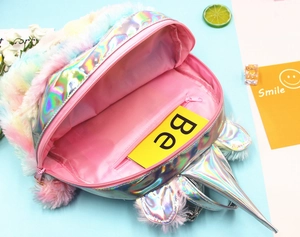 Detail view of unicorn plush backpack interior with pink lining and secure zipper pocket