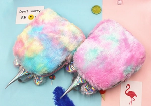 Top view of two colorful plush unicorn backpacks with holographic horns and fluffy texture