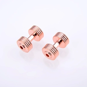Macro detail of rose gold dumbbell spacer beads with concentric ridges for DIY jewelry