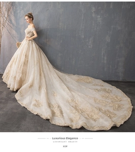 Luxurious off-shoulder wedding gown featuring exquisite lace embroidery and a long royal train