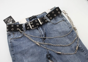 Detail of black double-grommet canvas belt with triple-layered metal punk style chains