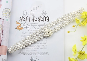 Detail of three-row pearl waist chain featuring a sparkling rhinestone flower buckle clasp