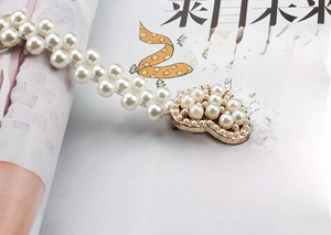Close-up of elegant double-row pearl belt with a heart-shaped pearl-encrusted buckle