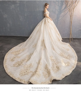 Close-up of golden floral embroidery and off-the-shoulder luxury bridal gown details