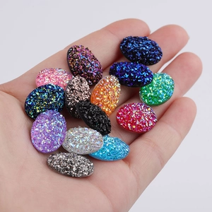 Detailed view of 13x18mm oval resin glitter cabochons in various sparkling colors