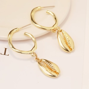 Detailed view of bohemian gold shell drop earrings featuring a polished C-ring design