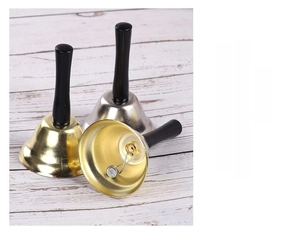 Close-up van goud en zilver metalen handbellen met zwarte houten handvaten op hout
