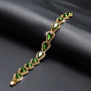 Bracelet élégant en or avec cristaux vert goutte d'eau sur fond en cuir noir texturé