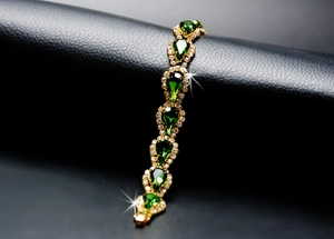 Détail macro du bracelet en or avec cristal poire vert et diamants clairs