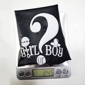 Weight detail of a black gender reveal balloon showing 24.5g on a digital scale