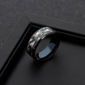 Close-up of wide black camo titanium ring with silver textured camouflage pattern inlay