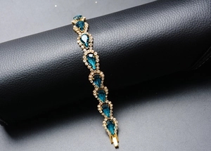 Gros plan du bracelet en cristal goutte bleue avec strass scintillants sur support cuir