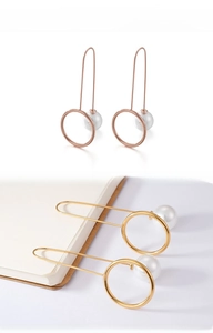 Detail view of geometric round pearl earrings in rose gold and gold finishes