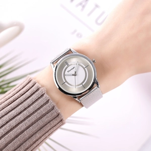 Close-up of a silver mesh strap quartz watch on a female wrist with minimalist dial