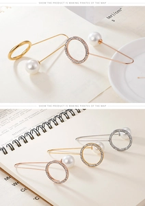 Detailed view of assorted metal circle pins with large faux pearls in gold and silver finishes