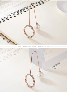 Detail of rose gold U-shaped earrings with paved crystal ring and round white pearl