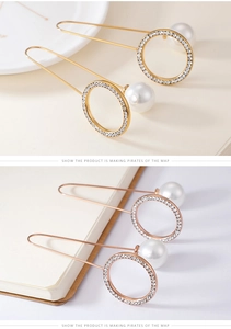 Detail of long pearl pin earrings with pavé zircon circle in gold and rose gold tones