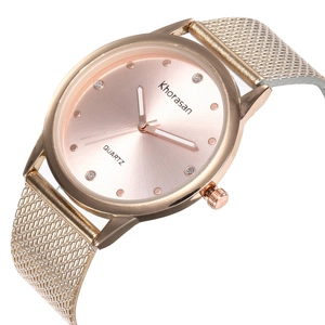 Détail d'une montre à quartz or rose avec bracelet en maille et index en strass sur cadran