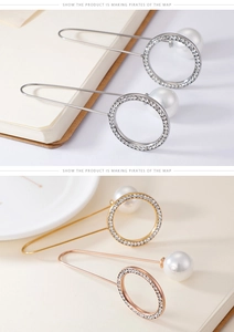 Macro shot of elegant circular rhinestone pins with large white pearls in gold and silver