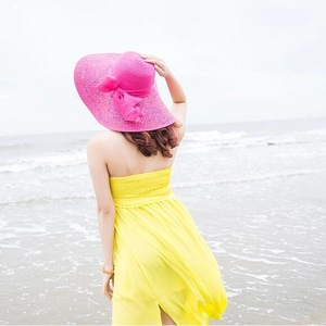 Rückansicht Strohhut mit rosa Schleife und breiter Krempe im Strandurlaub